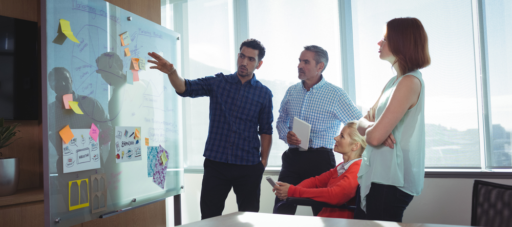 meeting around a glass whiteboard